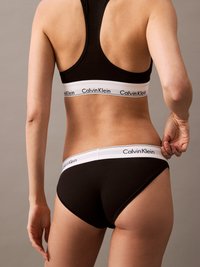 Svart bomull sports-bh og truse-sett med en hvit midjebånd som har "Calvin Klein"-logo. Enkelt, sømløst design, ingen synlige mønstre.