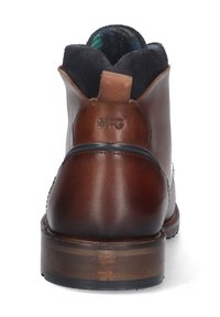 Bota de cuero marrón con un acabado suave, punta redondeada y tacón bajo apilado. Presenta un forro de tela con un cuello estampado. Logo de M.G. en la parte trasera.