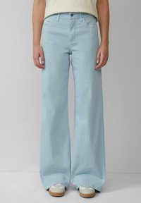 Hellblaue weite Beine Jeans mit hoher Taille, aus Denim gefertigt, mit einem Knopf- und Reißverschluss sowie seitlichen Taschen.