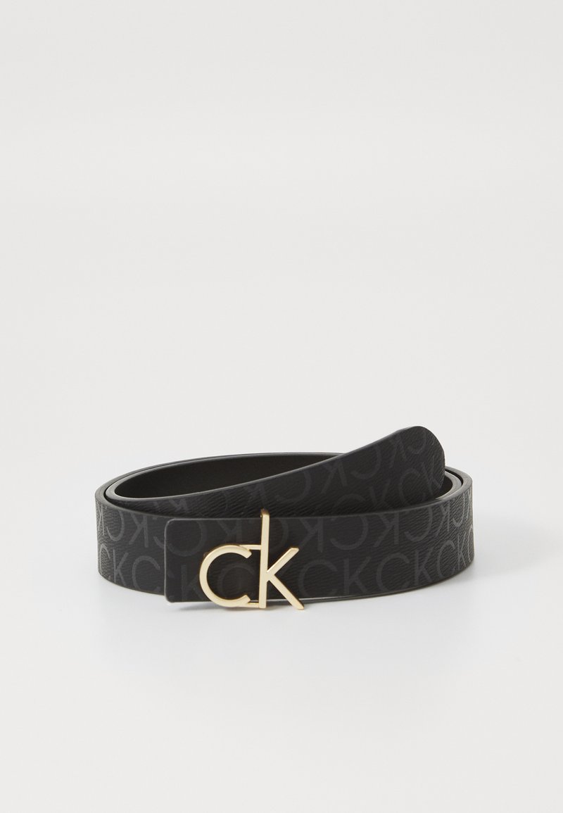 Czarny skórzany pasek z wytłoczonym wzorem CK oraz klamrą w odcieniu złota z logo CK, charakteryzujący się gładką powierzchnią i eleganckim designem.