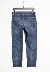 Jeans de mezclilla azul oscuro, colgados, con un diseño de pierna recta, bolsillos traseros visibles y detalles de costura sutiles.