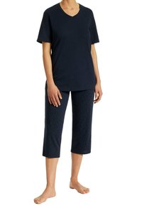 Navy v-neck t-shirt paired with knee-length navy pants featuring white polka dots. Cotton material, relaxed fit, and short sleeves.