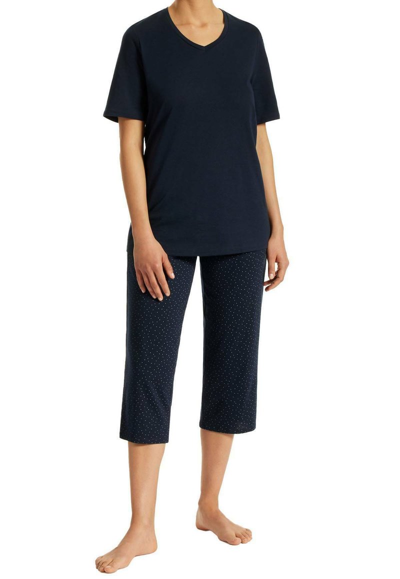 Navy v-neck t-shirt paired with knee-length navy pants featuring white polka dots. Cotton material, relaxed fit, and short sleeves.