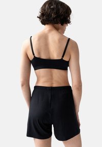 Zwarte sportbeha en shortset gemaakt van gladde stof, met verstelbare banden en een elastische tailleband voor comfortabel draaggevoel.