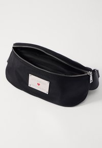 Schwarze Nylon-Gürteltasche mit silberner Logoplatte, Reißverschluss und verstellbarem Riemen. Glatte Textur mit einem schlichten, runden Design.