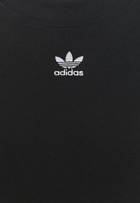 Svart t-shirt med rund halsringning och korta ärmar. Har en liten vit broderad Adidas-logotyp på bröstet. Mjuk textur.