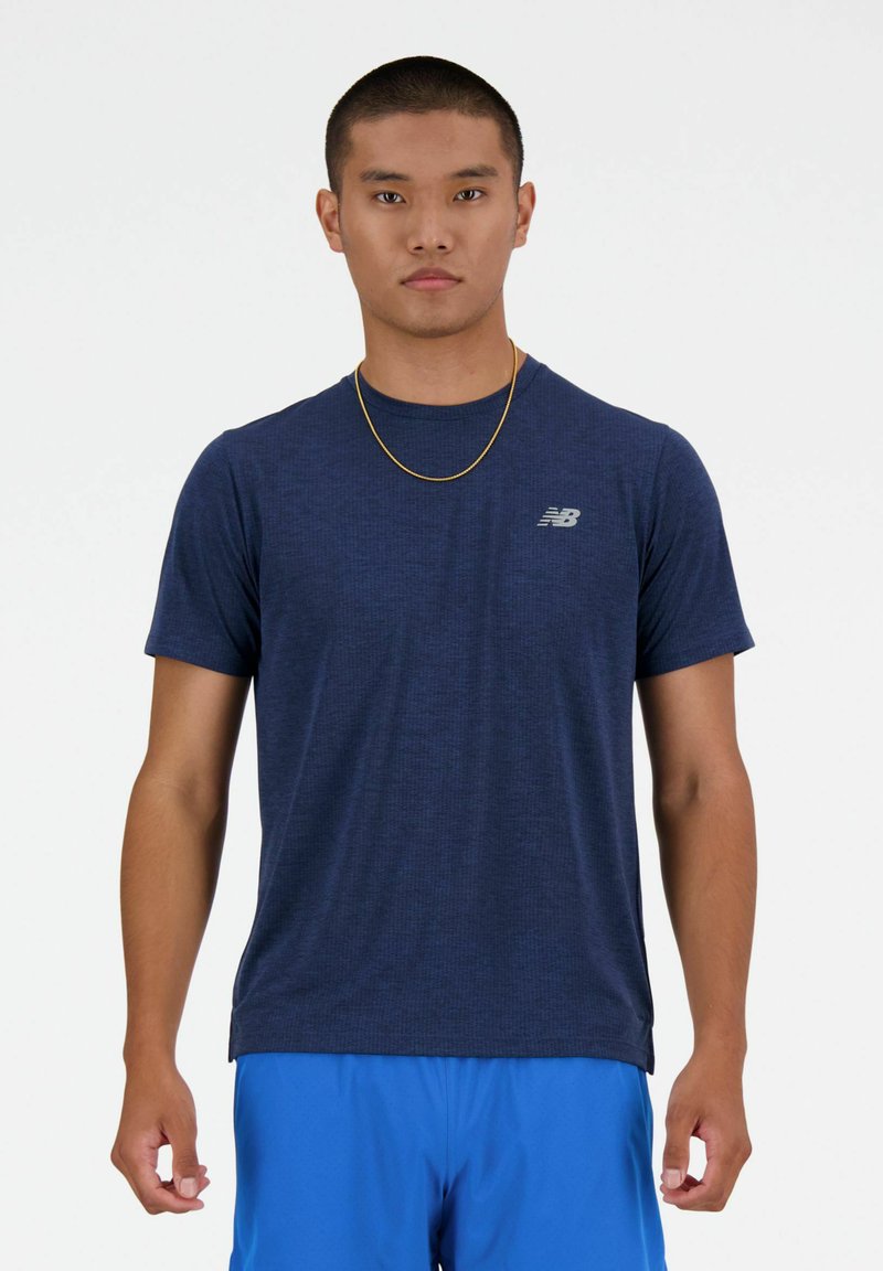 T-shirt sportivo blu navy realizzato in un tessuto testurizzato e traspirante. Presenta un logo grigio sul petto sinistro e un collo rotondo.