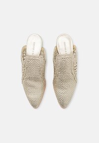 Mules en or tissés avec des bouts pointus et des dos ouverts. Possède une finition texturée et une doublure intérieure lisse avec un logo embossé.
