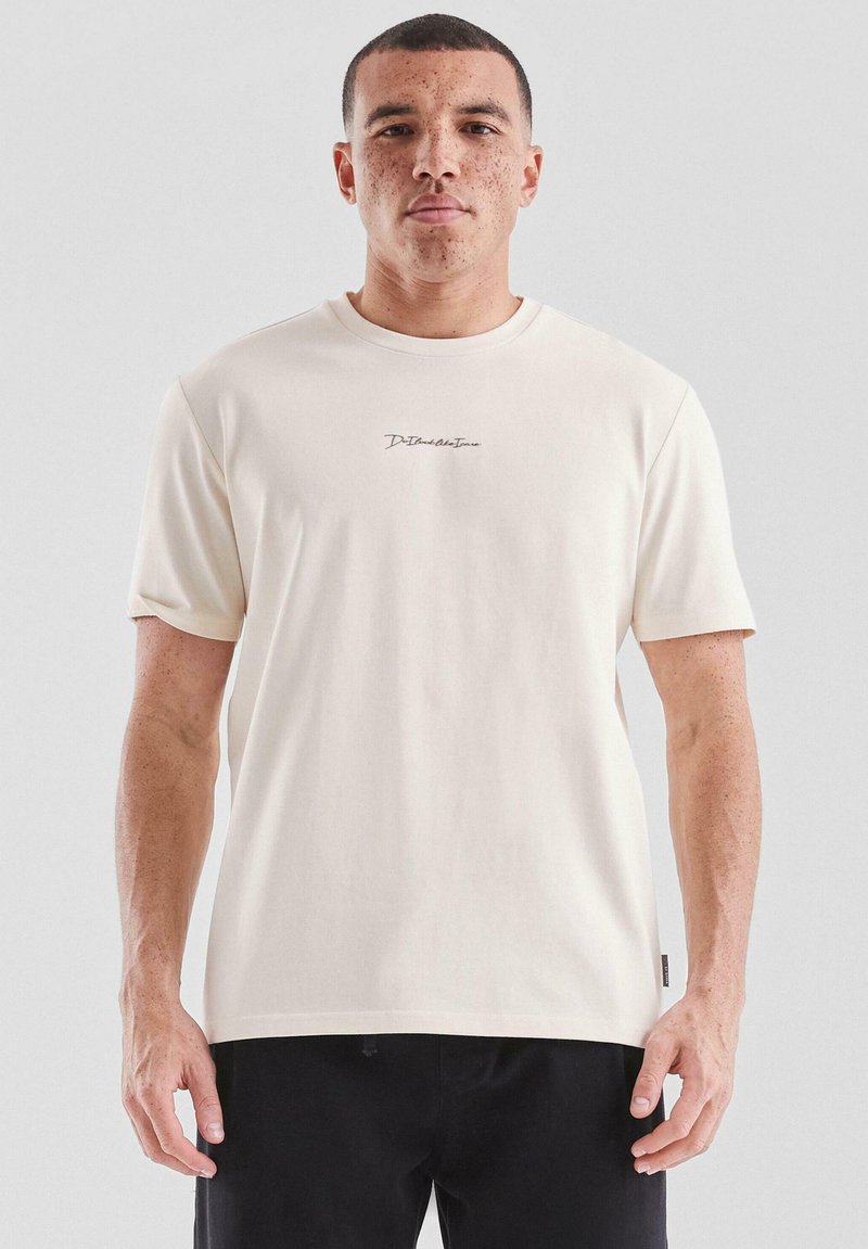 Crème-kleurig t-shirt van zacht, glad weefsel met korte mouwen. Voorzien van een klein, donker logo geborduurd op de borst.