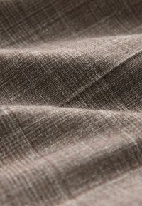 Strukturiertes Gewebe in Brauntönen, das ein dezentes Muster mit gewebtem Aussehen zeigt und verschiedene helle und dunkle Fäden aufweist.