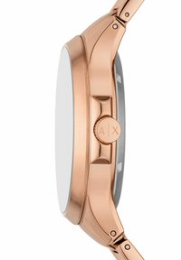 Orologio in metallo rose gold con cassa liscia e arrotondata, corona rettangolare e finitura lucida. Presenta un quadrante minimalista e un bracciale a maglie.