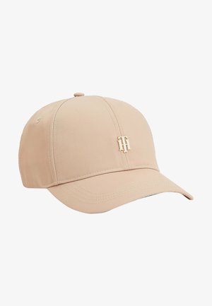 Casquette de baseball beige clair avec une visière incurvée et un logo métallique doré "TH" entrelacé sur le panneau central avant.