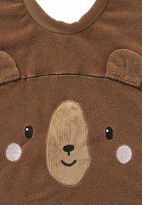 Braunes Stoff-T-Shirt mit Bärengesicht-Design, texturierten Ohren, bestickten Augen und einem lächelnden Mund. Weiches und gemütliches Material.