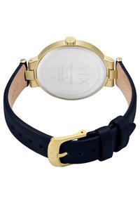 Guldtonad rostfritt stål klocka med silverfärgad urtavla, marinblå läderrem och guldklicka. Har en minimalistisk design och enkla accenter.