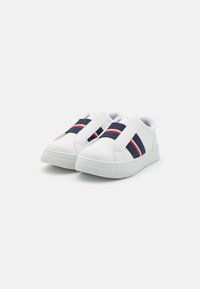 Adidași albi cu benzi elastice în dungi bleumarin și roșii. Material sintetic neted, vârf rotunjit, talpă texturată, design low-top.