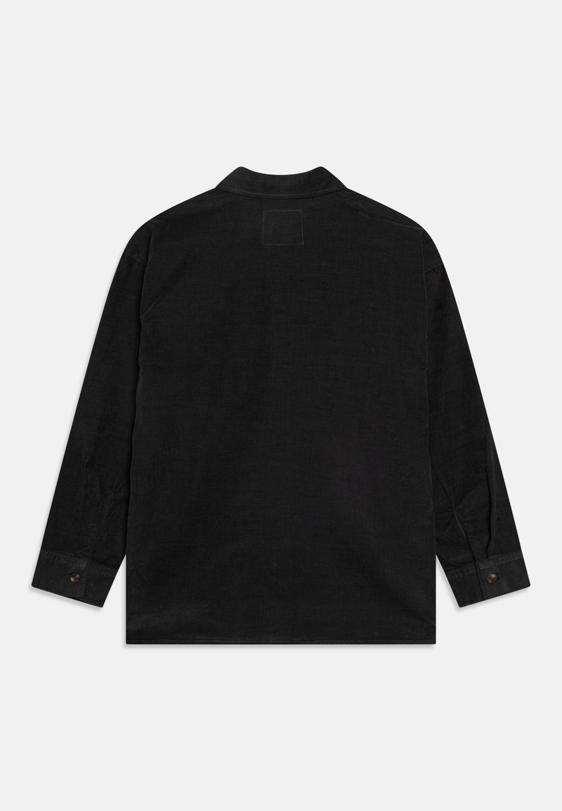 Camicia overshirt in corduroy nero con colletto, maniche lunghe e polsini con bottone. Presenta un'etichetta rettangolare sul retro della spalla. Tessuto con texture.