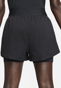 Zwarte sportshorts met een hoge tailleband, met een gelaagd ontwerp en een soepele textuur. Binnenste shorts bieden extra bedekking.