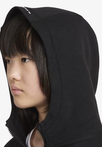 Μαύρο φούτερ με φερμουάρ και λεία υφή, με εφαρμοστό κουκούλα. Διαθέτει λεπτομέρειες ραφής και φερμουάρ μπροστά.