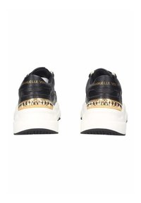 Sneaker in pelle nera con dettagli dorati e suole bianche. Presenta un retro testurizzato, dettagli con logo e un design a piattaforma.