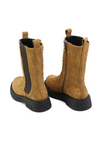 Botas de tobillo de ante marrón con un acabado texturizado, paneles laterales elásticos negros y suela de goma negra. Cuenta con un cierre de cremallera en la parte trasera.