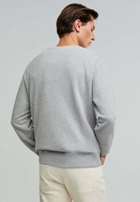 Gray sweatshirt made of soft fabric, featuring a crew neckline, long sleeves, and ribbed cuffs and hem. Simple design, no patterns.