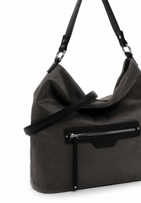 Schwarze Canvas-Handtasche mit weichem, lässigem Design. Verfügt über eine vordere Reißverschlusstasche und zwei strukturierte schwarze Tragegurte. Glatte Oberfläche mit matter Optik.