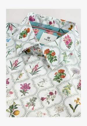 Fehér ing, amely virágmintával rendelkezik, különböző színekben, mintás gallérral és gomb részletekkel. Márkacímke látható belül.