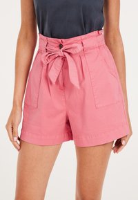 Shorts in cotone rosa con vita annodata, due tasche laterali e vestibilità comoda. Presentano una chiusura a bottoni e dettagli a pieghe.