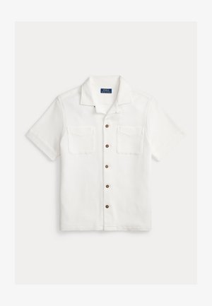 Biela košeľa s krátkym rukávom a zapínaním na gombíky, vyrobená z textúrovanej látky s dvoma náprsnými vreckami a hnedými gombíkmi vpredu. Dizajn s golierom.