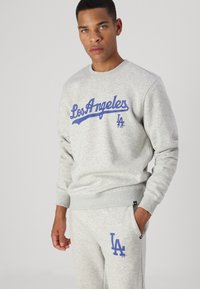 Grau sweatshirt und Jogginghose mit blauem "Los Angeles"-Text. Weicher Stoff, gerippte Bündchen und Logo-Detail an der Hose.