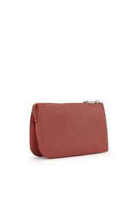 Funda rectangular suave en un color rosa apagado, hecha de un tejido texturizado, que cuenta con un cierre superior de cremallera y detalles de costura sutiles.