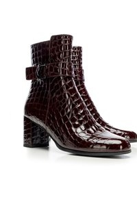 Bordeaux kotníkové boty s lesklým povrchem, s krokodýlí texturou, špičatou špičkou a čtveratým blokovým podpatkem. Nastavitelný pásek s kovovou sponou.