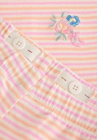 Bavlněný top s růžovými a oranžovými pruhy, zdobený květinovou výšivkou v pastelových barvách; má bílý knoflík a elastický pas.