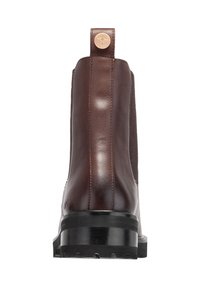 Brown leather chelsea boot with elastic side panels, flat black rubber sole, and embossed logo detail on the back. Sleek and structured design.