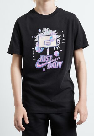 Dziecko w czarnej koszulce z kolorowym obręczą do koszykówki, unoszącymi się piłkami do koszykówki i logo Nike "Just Do It" na środku z przodu.