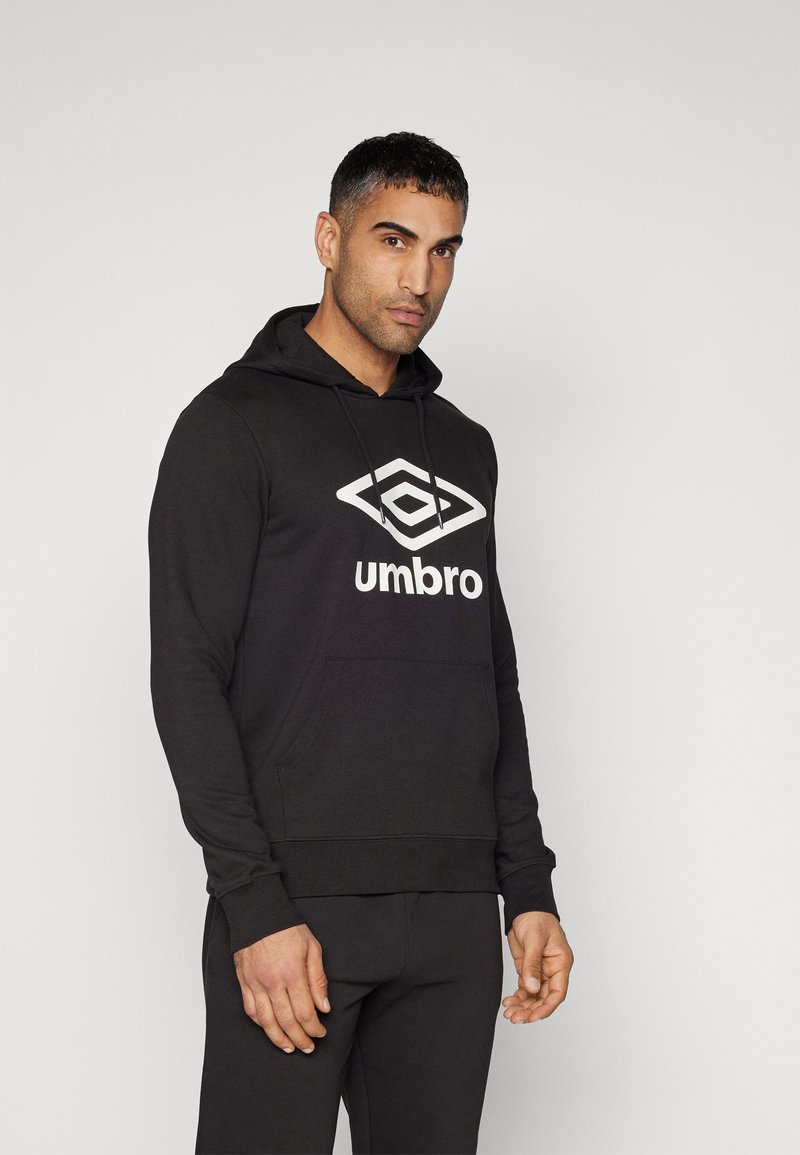 Čierna mikina s kapucňou vyrobená z bavlnenej zmesi, s veľkým bielym logom "Umbro" vpredu, klokaniu vreckom a rebrovanými manžetami.
