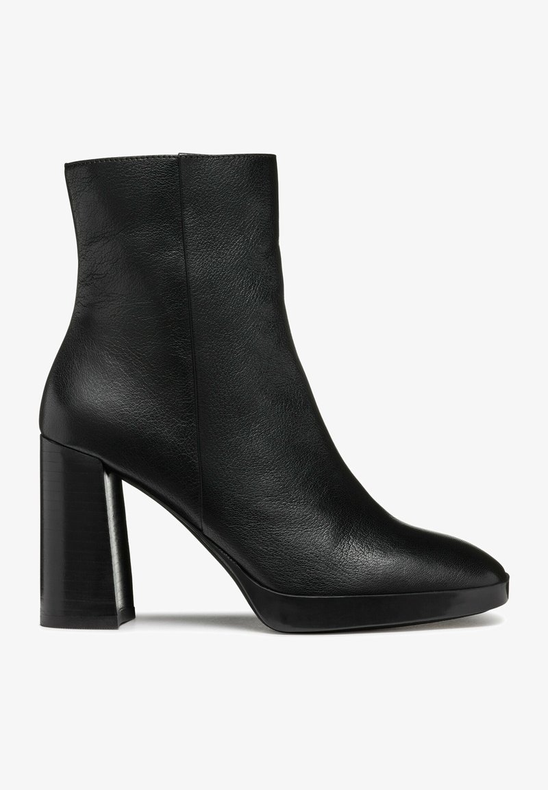 Bottine en cuir noir avec un bout arrondi et un talon bloc épais et haut, texture lisse et détail de couture latérale.