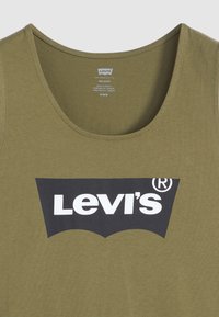 Olivinės spalvos medvilnės marškinėliai be rankovių su apvaliu iškirpimu ir juodu Levi's logotipo grafiniais elementais priekyje. Tekstūruota, lengva medžiaga.