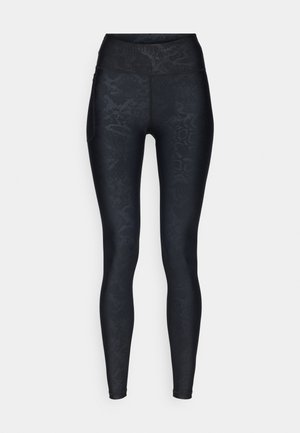 Zwarte legging met een gestructureerd slangenhuidpatroon, hoge tailleband en gladde stof. Bevat een zijzak voor kleine voorwerpen.