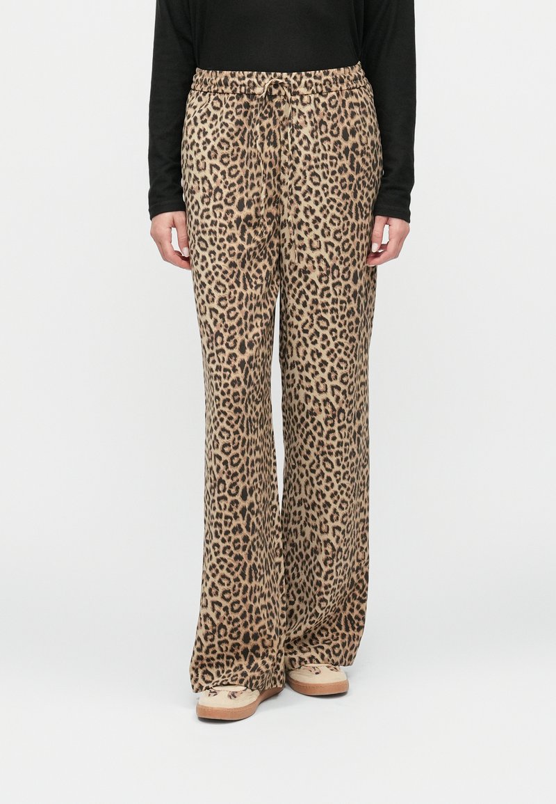 Laukuvilnas platās kājas bikses ar leopardu rakstu, izgatavotas no mīksta auduma, ar elastīgu jostu un auklu. Krāsu toņi ietver brūnu un melnu.