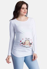 Weißes, langärmliges Stillshirt mit einem Cartoon-Design, das ein lächelndes Baby und Herzen zeigt. Hergestellt aus weichem Stoff mit Raffung an der Seite.
