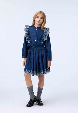 Abito in denim con colletto e polsini con volant, di colore blu, vita elastica, gonna a strati e ricami floreali bianchi all'orlo.