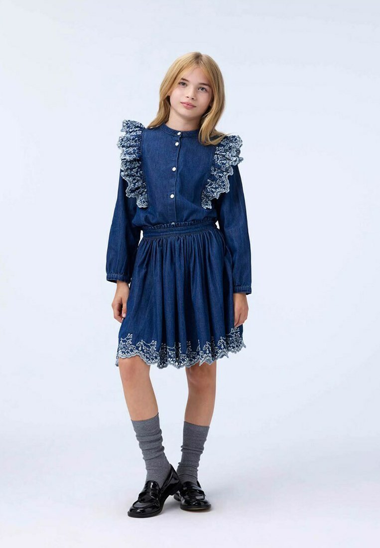 Denimová šaty s volánovým límcem a manžetami, modré barvy, s elastickým pasem, vícevrstvou sukní a bílou květinovou výšivkou na lemu.