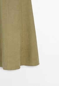 Jupe en lin vert olive à coupe évasée, avec des détails de couture et une texture lisse, se terminant juste en dessous du genou.