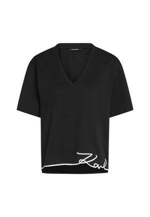 Schwarzes V-Ausschnitt-T-Shirt aus Baumwolle mit kurzen Ärmeln, das am Saum mit einer weißen gestickten Unterschrift versehen ist. Lässige Passform und glatte Textur.