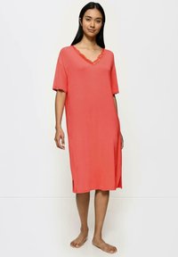 Korala nocna koszula z miękkiej, gładkiej tkaniny, z krótkimi rękawami, dekoltem w serek i koronkowym wykończeniem. Posiada boczne rozcięcia dla swobody ruchów.