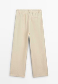 Pantalon beige à jambes larges avec taille élastique et une seule poche passepoilée à l'arrière, vu de dos sur fond blanc.