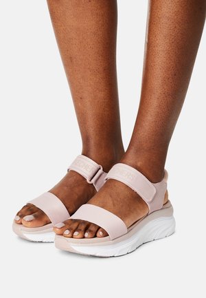 Sandali Skechers rosa chiaro con cinturini regolabili, suola bianca ammortizzata e punte scoperte. Caratteristiche di tessuto morbido e design resistente.