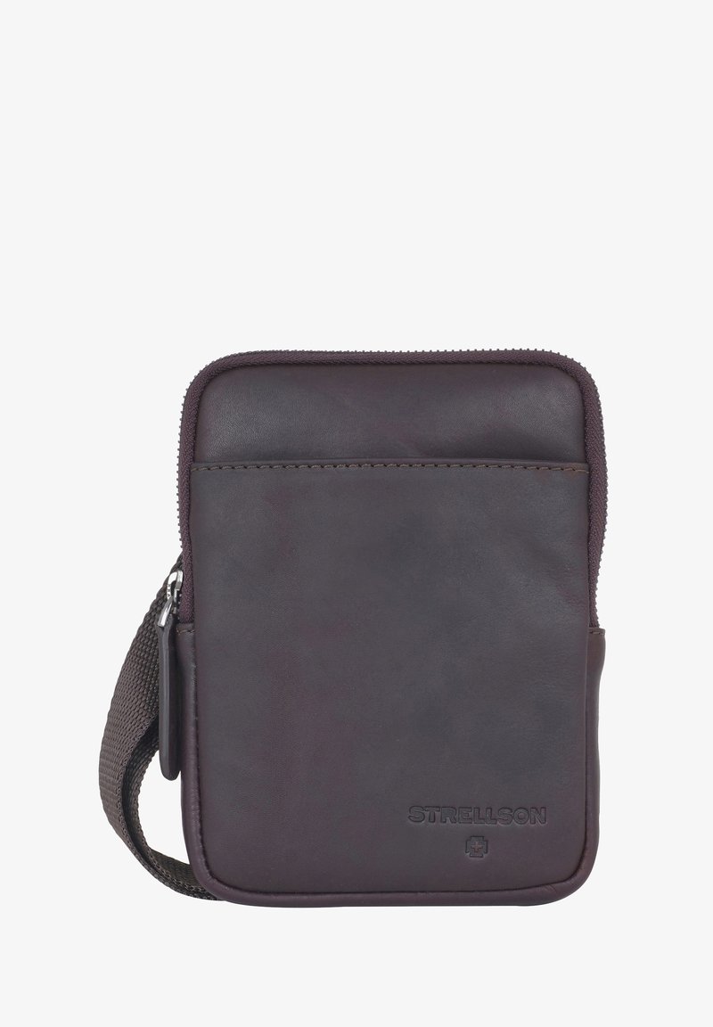 Pochette en cuir marron avec fermeture éclair, sangle en tissu et logo en relief ; présente une surface lisse et un design minimaliste.