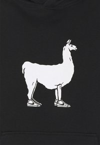 Černá mikina s kapucí, na které je bílý grafický motiv stojící lamy v teniskách, která ukazuje svůj jedinečný tvar a kontrastní barvy.